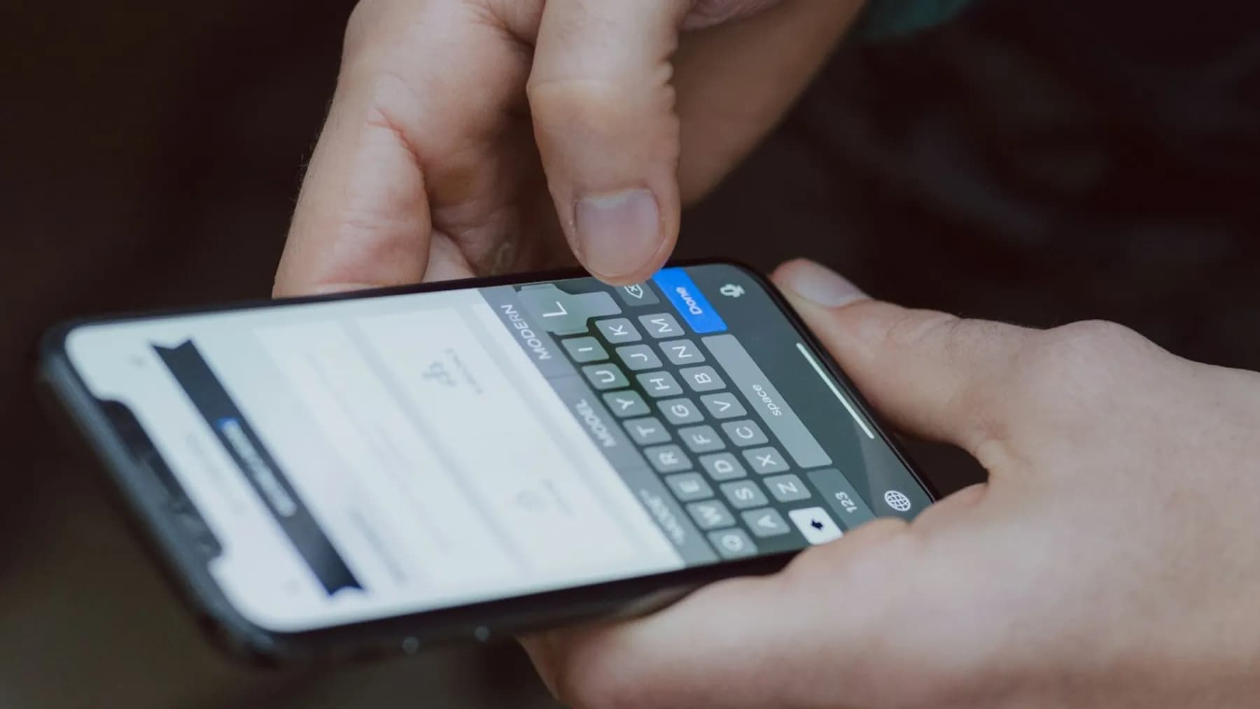 Hände tippen eine Nachricht auf einem Smartphone